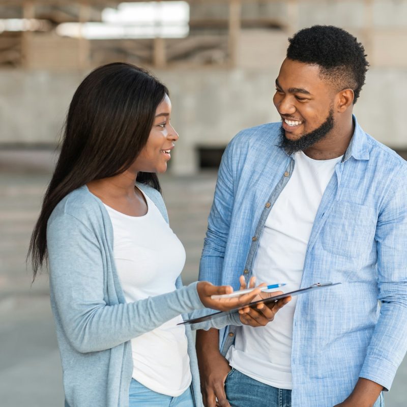 Black female volunteer conducting survey with young man on the street