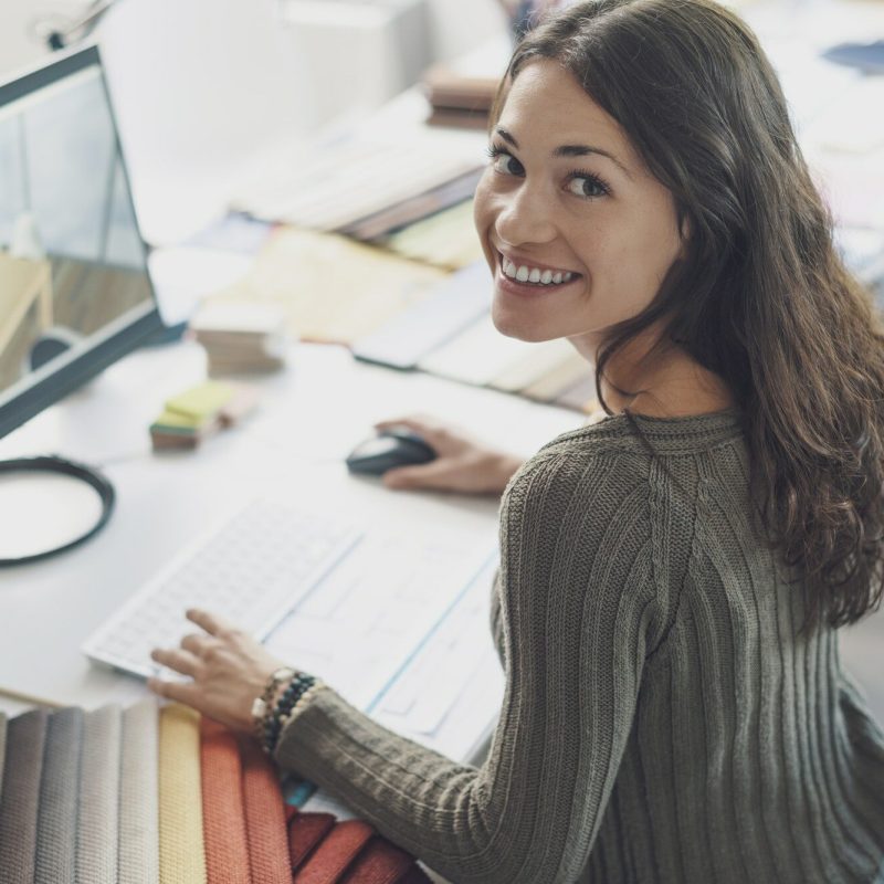 Smiling interior designer working at desk